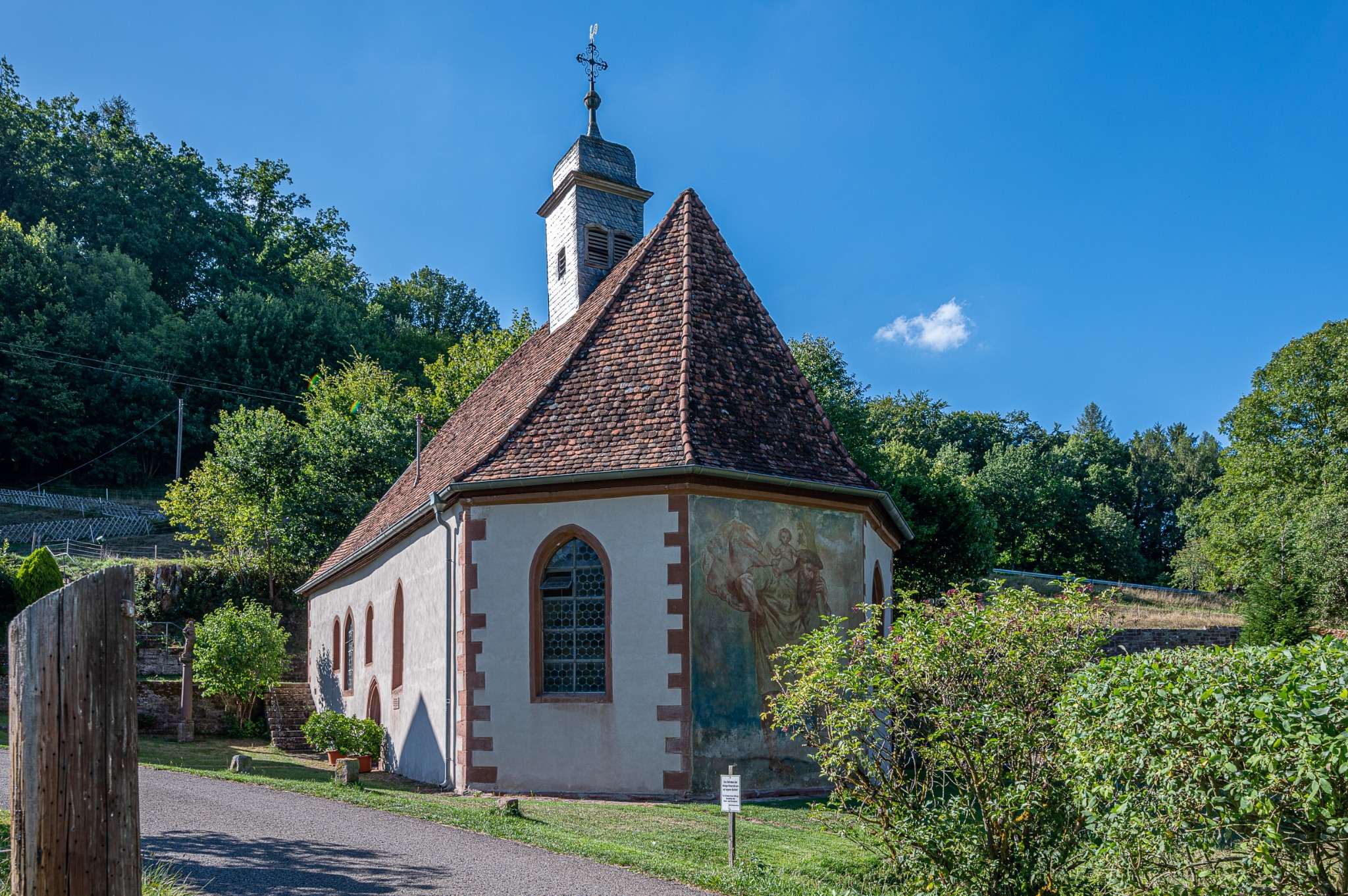 Chapelle rénovée avec toit en tuiles anciennes et fresque murale – architecture patrimoniale